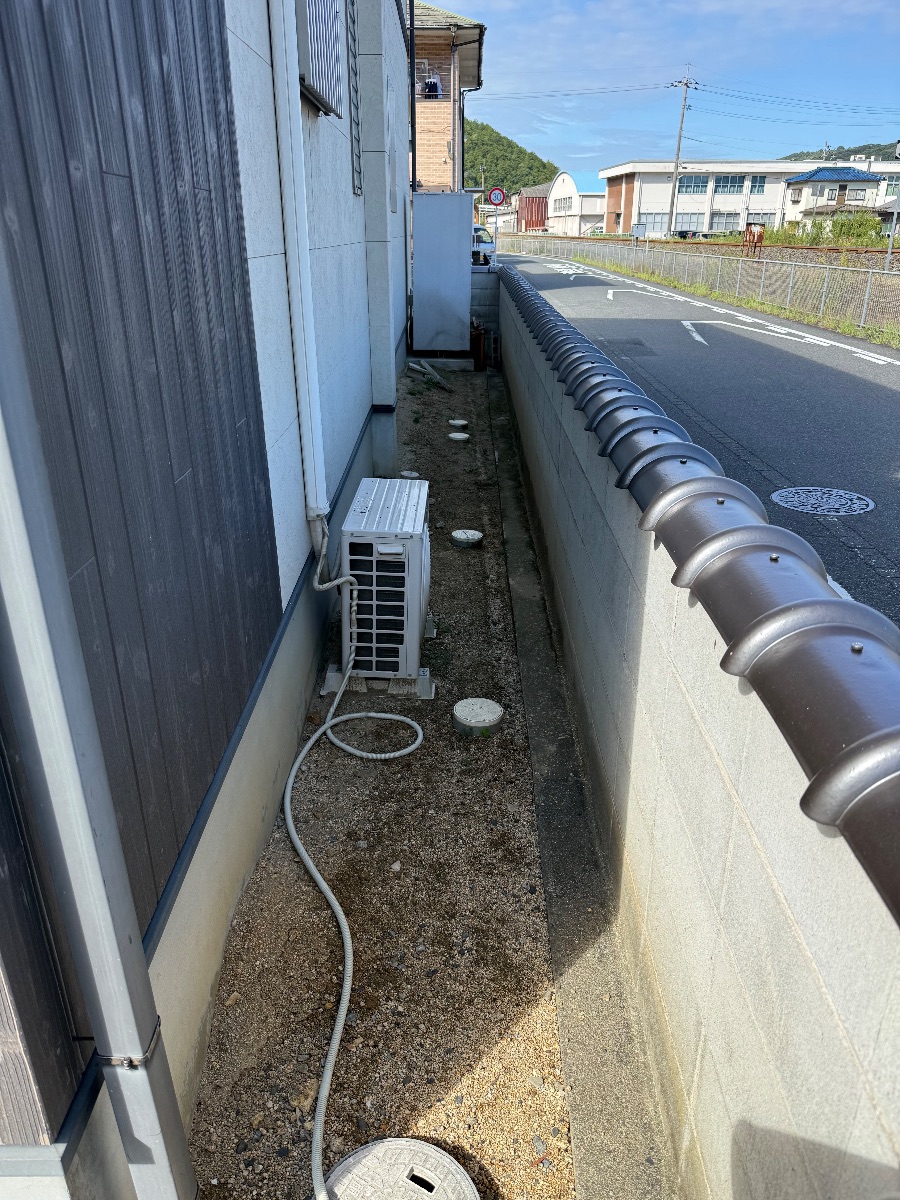井原市 防草シート施工前 建物側面の細い通路とエアコン室外機